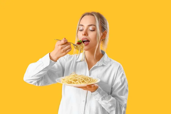 Νεαρή Γυναίκα Τρώει Νόστιμα Ζυμαρικά Κίτρινο Φόντο — Φωτογραφία Αρχείου