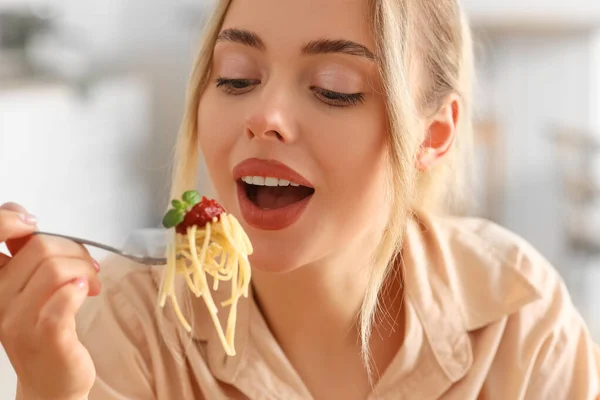年轻女人在厨房里吃着美味的意大利面 特写镜头 — 图库照片