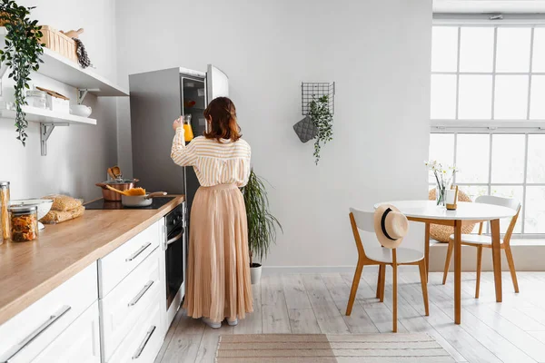 Ung Kvinna Öppnar Elegant Kylskåp Köket — Stockfoto