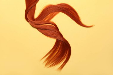 Sarı arka planda kızıl saç teli, yakın plan.