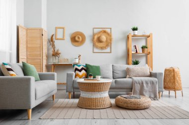 Oturma odasının içinde raflar, masa ve kanepeler var.