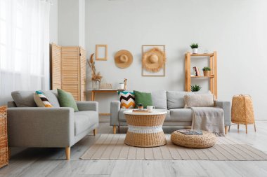 Oturma odasının içinde raflar, masa ve kanepeler var.