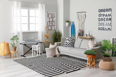 Sörf tahtası, sentezleyici ve kanepesi olan şık bir oturma odası.