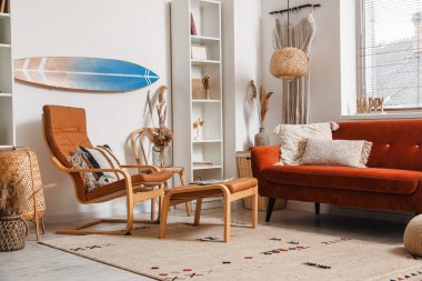 Sörf tahtası, kahverengi kanepesi ve koltuğu olan bir oturma odası.