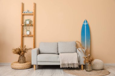 Sörf tahtası, raf ünitesi ve kanepesi olan modern şık bir oda.