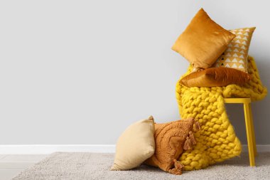 Odada şık yastıklı ve ekoseli sandalye var.