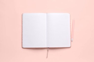 Pembe zemin üzerinde kalem olan boş bir defter aç