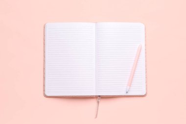 Pembe zemin üzerinde kalem olan boş bir defter aç