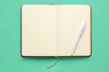 Renk arkaplanı üzerine boş defter ve kalem aç