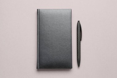 Gri arkaplanda boş defter ve kalem