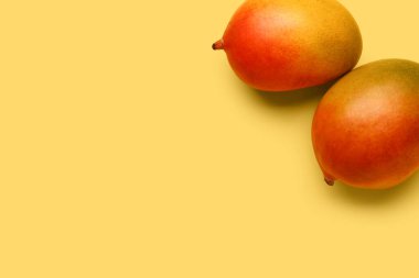 Sarı arka planda taze mangolar.