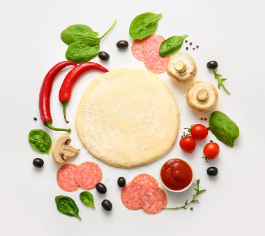Beyaz arka planda pizza hazırlamak için ham hamur ve malzemeler