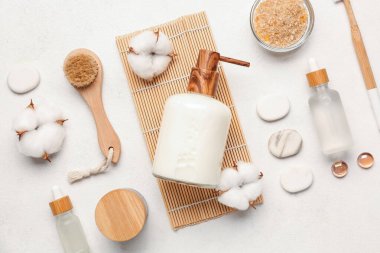 Kozmetik ürünlerle, banyo malzemeleriyle ve arka planda pamuk çiçekleriyle kompozisyon