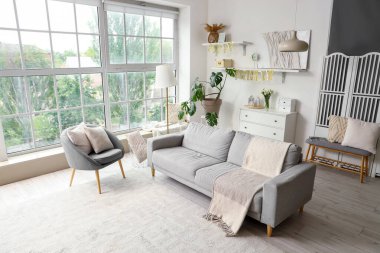 Oturma odasının içi, doğum günü partisi için koltuk ve koltukla dekore edilmiş.