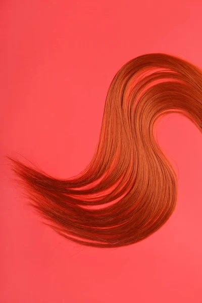 Ruda Kosmyk Włosów Czerwonym Tle Zbliżenie — Zdjęcie stockowe
