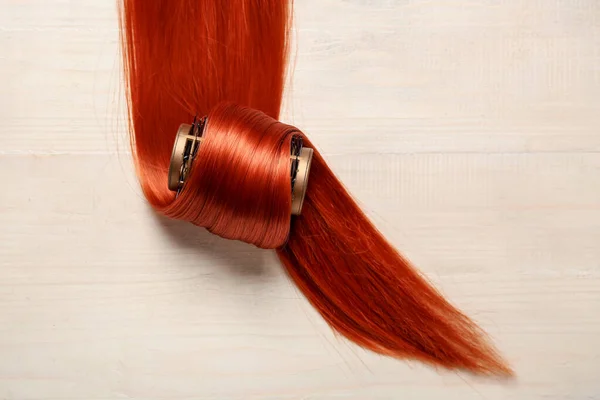 轻质木制背景的带卷曲的生姜发丝 — 图库照片