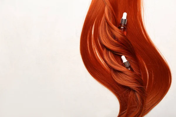 Piękne Rude Włosy Butelkami Olejku Eterycznego Jasnym Tle Zbliżenie — Zdjęcie stockowe