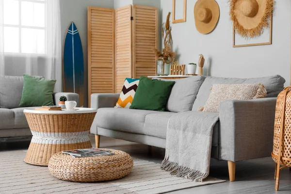 stock image Interior of light living room with surfboard, table and sofas