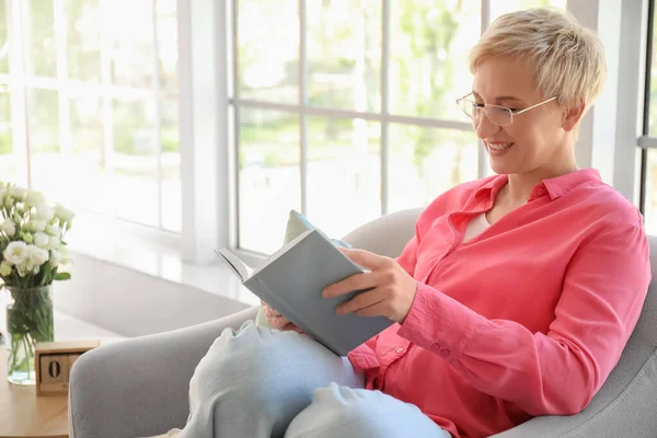 Mature Woman Reading Book Armchair Home — Stock Photo, Image