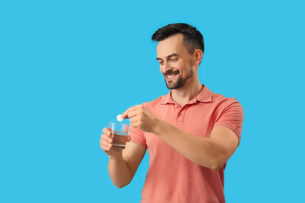 Junger Mann Steckt Lösliche Tablette Glas Wasser Auf Blauem Hintergrund — Stockfoto