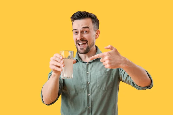 Junger Mann Mit Aufgelöster Tablette Und Wasserglas Auf Gelbem Hintergrund — Stockfoto