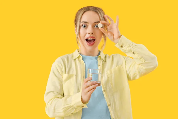 Młoda Kobieta Rozpuszczalną Tabletką Szklanką Wody Żółtym Tle — Zdjęcie stockowe