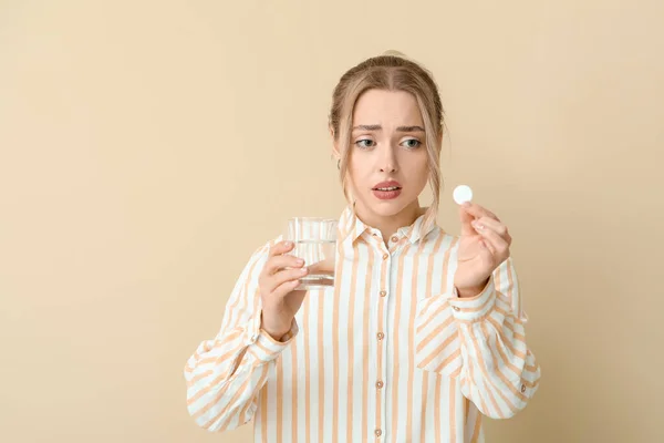 Młoda Kobieta Rozpuszczalną Tabletką Szklanką Wody Beżowym Tle — Zdjęcie stockowe