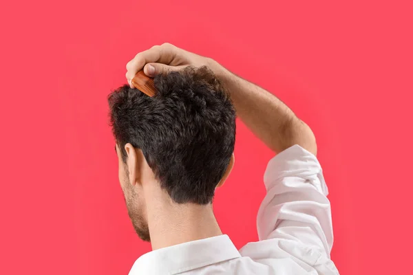 Молодий Брюнетка Чоловік Розчісує Волосся Червоному Тлі Крупним Планом — стокове фото