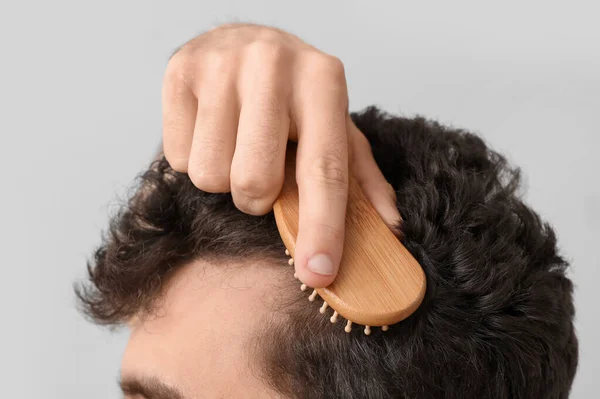 Young Brunette Man Brushing Hair Light Background Closeup — Stock Photo, Image