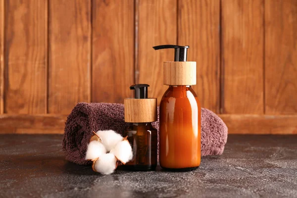 Flaschen Kosmetikprodukte Sauberes Handtuch Und Baumwollblume Auf Dunklem Tisch Vor — Stockfoto