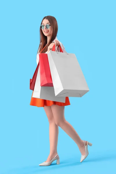 Jonge Vrouw Met Boodschappentassen Blauwe Achtergrond — Stockfoto