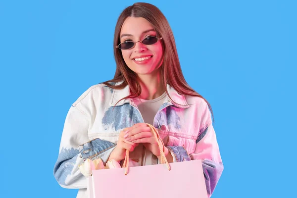 Mavi Arka Planda Alışveriş Torbaları Olan Genç Bir Kadın — Stok fotoğraf