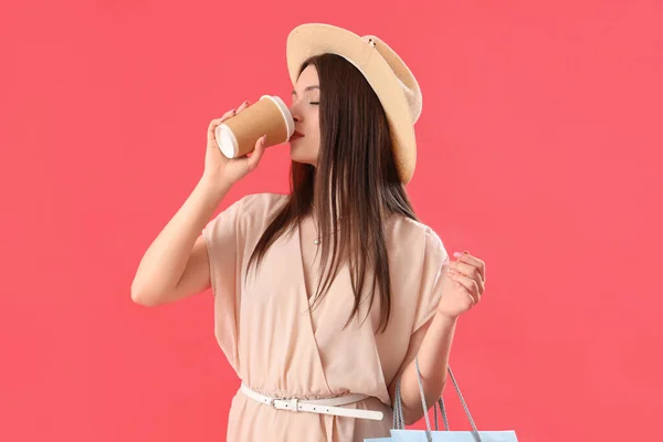 Молодая Женщина Пакетами Покупок Пьет Кофе Красном Фоне — стоковое фото