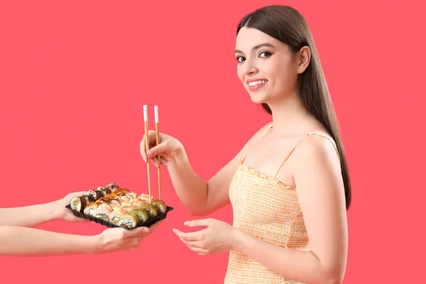 Young Woman Taking Sushi Red Background — Stock Photo, Image