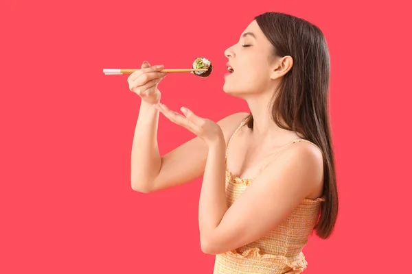 Jeune Femme Manger Sushi Rouleau Sur Fond Rouge — Photo