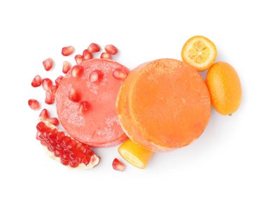 Beyaz arka planda turuncu, kumkatlı ve nar aromalı renkli katı şampuan çubukları.