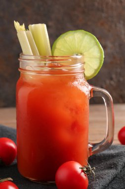 Mason kavanozu koyu arkaplanda kereviz ve limonlu Bloody Mary.