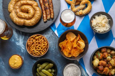 Soğuk bira bardakları ve mavi arka planda farklı atıştırmalıklar. Ekim Festivali Kutlaması