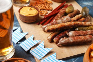 Ahşap tahta tahta, mavi arka planda farklı atıştırmalıklar. Ekim Festivali Kutlaması