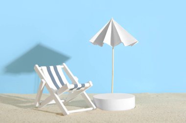 Dekoratif alçı podyum, güverte sandalyesi ve şemsiyeli yaratıcı kompozisyon.