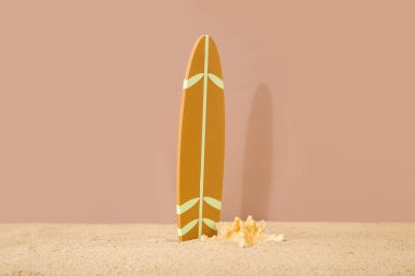 Kahverengi arka planda deniz yıldızı olan mini sörf tahtası.