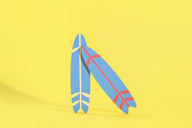 Sarı arka planda mini sörf tahtaları