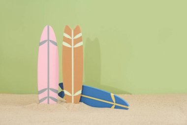 Farklı renkte mini sörf tahtaları ve zeytin arkaplanı.