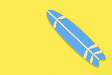 Sarı arka planda mini sörf tahtası