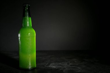 Koyu arka plan üzerinde soğuk bira şişe