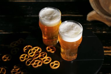 Koyu arkaplanda kraker ve soğuk bira bardakları.