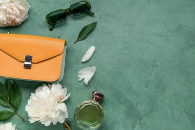 Şık kadın aksesuarları, bir şişe parfüm ve renkli fonda güzel şakayık çiçekleri olan kompozisyon.