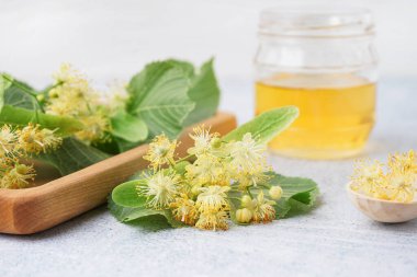 Taze ıhlamur çiçekli ahşap tahta ve arka planda bal, yakın plan.