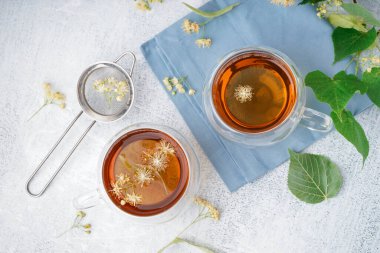 Beyaz arka planda bir bardak ıhlamur çayı.