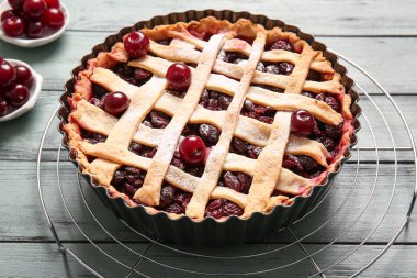 Mavi ahşap zemin üzerinde vişneli turta ile pişirme yemeği